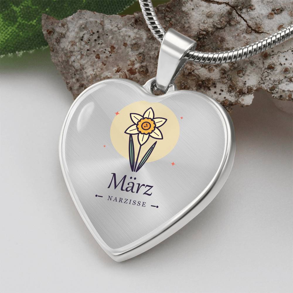 Nahaufnahme der Narzisse als Geburtsblume März auf herzförmigem Anhänger