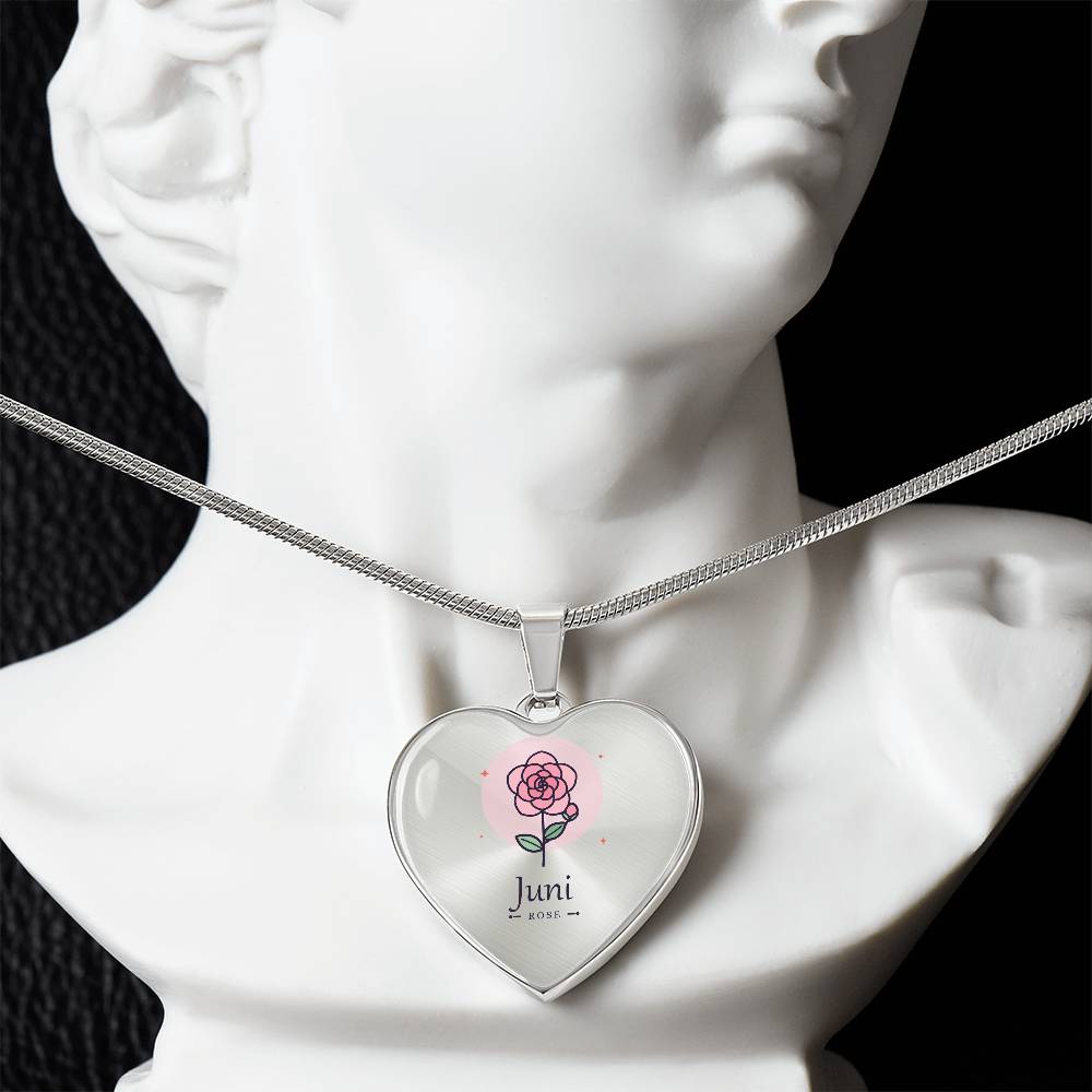 Nahaufnahme der Rose als Geburtsblume Juni auf herzförmigem Anhänger
